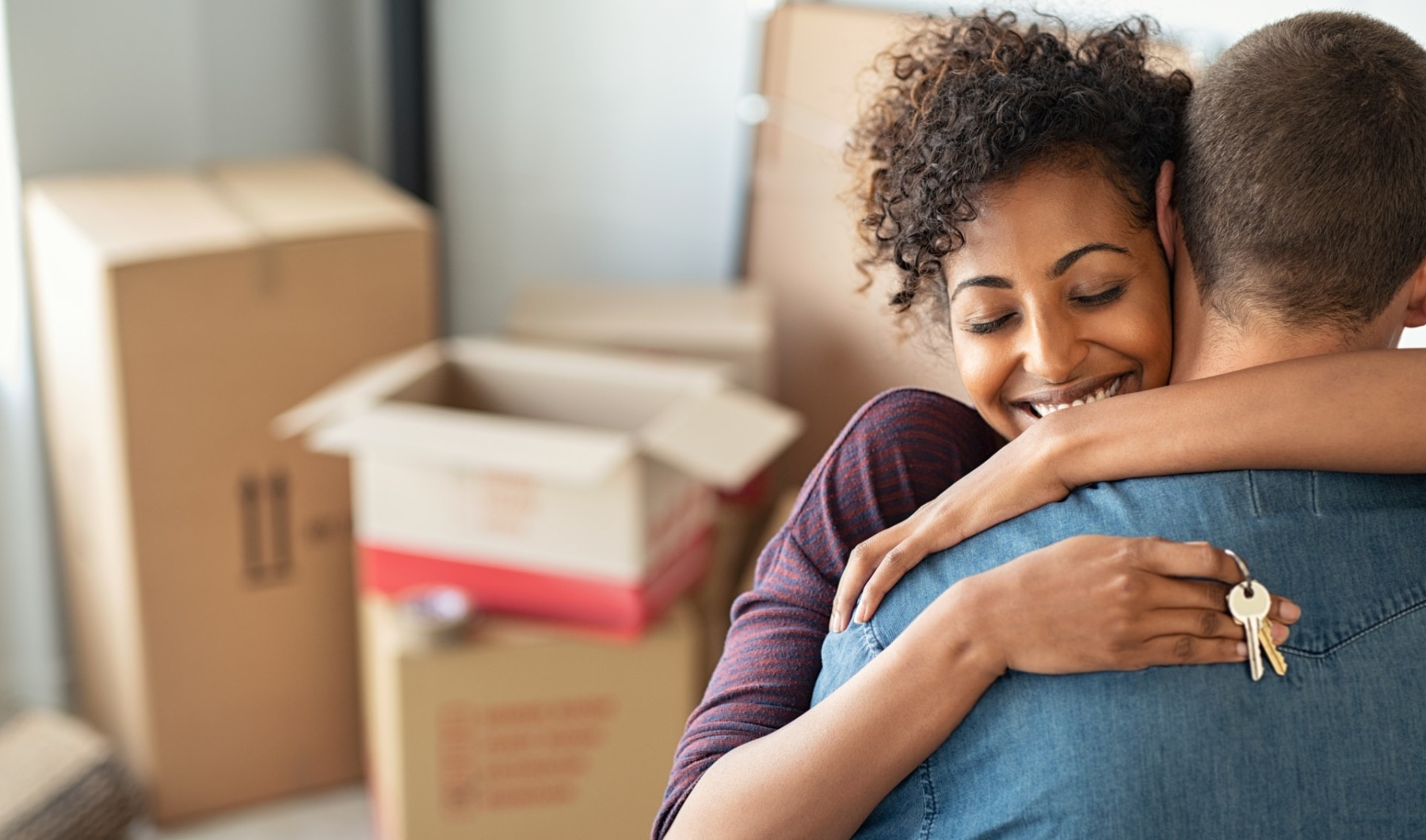 woman hugging man with keys in hand